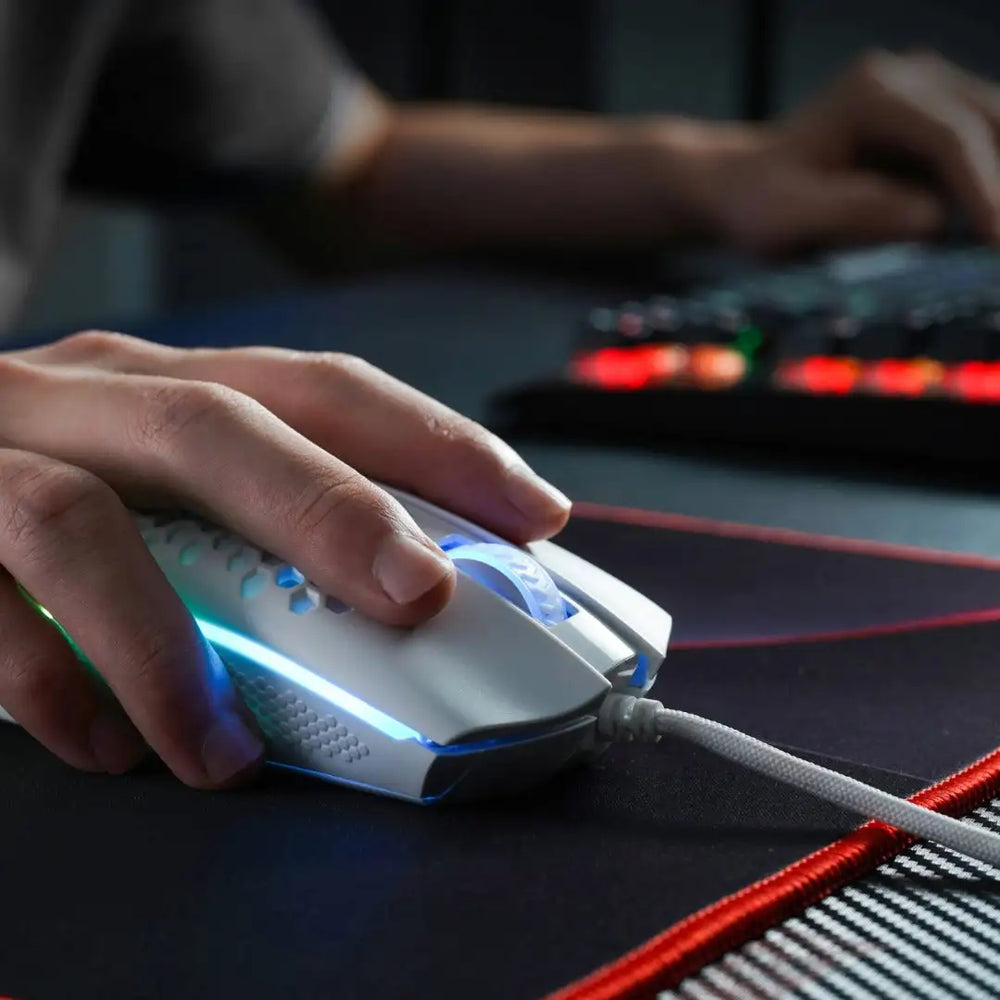 Souris de gaming blanche avec éclairage LED bleu et une poignée texturée.